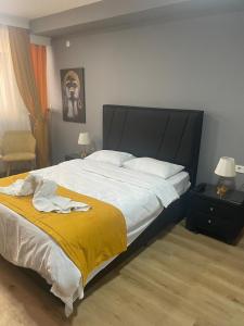 ein Schlafzimmer mit einem großen Bett und einer gelben Decke in der Unterkunft BY KARAM OTELCİLİK in Istanbul