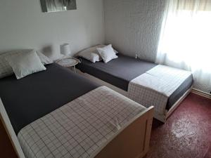 two beds in a small room with a window at Apartman Batarelo in Gornji Karin