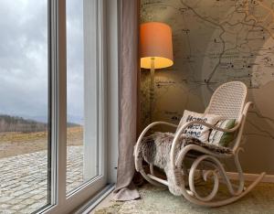 a rocking chair in a room with a window at Dom Gościnny Wróbliczówka in Sierpnica
