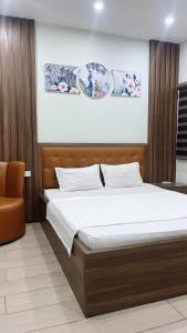 1 dormitorio con 1 cama grande y 1 silla naranja en Cường Thịnh Hotel, en Na Dao Tổng