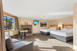 ein Hotelzimmer mit 2 Betten und einem Kamin in der Unterkunft Discovery Lodge in Estes Park
