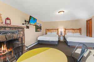 a hotel room with two beds and a fireplace at Discovery Lodge in Estes Park