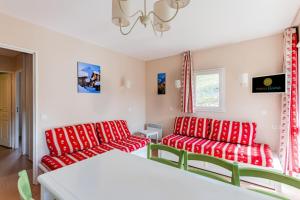 uma sala de estar com sofás vermelhos e uma mesa em Résidence Le Thabor - maeva Home - Appartement 3 pièces 6 personnes - Conf 734 em Le Désert