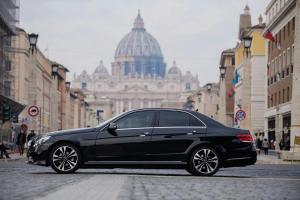 un coche negro aparcado en una calle de la ciudad en Ecclesia Domus Vatican Inn en Roma