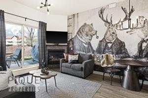 a living room with a mural of animals on the wall at Mountain Haven Retreat, Pool & Hot Tub, UG Parking, Fitness Centre, WiFi! in Canmore