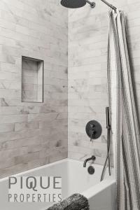 a white bathroom with a tub and a shower at Mountain Haven Retreat, Pool & Hot Tub, UG Parking, Fitness Centre, WiFi! in Canmore