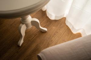 a wooden floor with a white table and a curtain at Noordzee, Hotel & Spa in Cadzand-Bad +38 photos