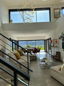 sala de estar con sofá y lámpara de araña en Villa Contemporaine avec Vue Imprenable en Peyruis