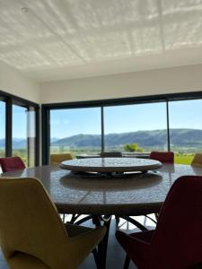 mesa de comedor con sillas y ventana grande en Villa Contemporaine avec Vue Imprenable en Peyruis