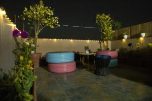 a patio with colorful stools and a table and lights at Sumptuous 1BHk Couple friendly in Lucknow