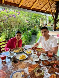 a man and a woman sitting at a table with food at Cabañas Bambu Mindo in Mindo