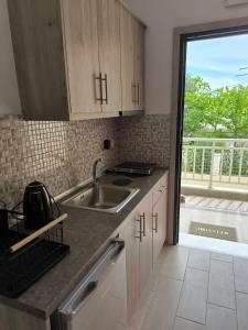 a kitchen with wooden cabinets and a sink and a window at VILLA SEVI in Nea Vrasna