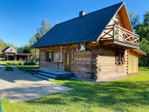 a small log cabin with a black roof at Sielankowe Pole in Józefów