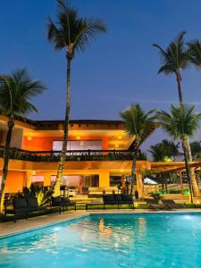 un hôtel avec une piscine en face d'un bâtiment dans l'établissement Luna Hotel Boutique - Beira Mar, à Guarujá