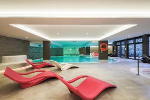 un vestíbulo con 3 zapatos rojos y una piscina en Résidence Premium L'Hévana - maeva Home - Appartement 2 pièces 4 personne 054, en Les Allues