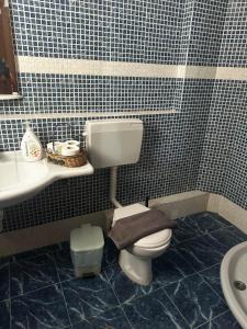 łazienka z toaletą i umywalką w obiekcie Pansion Angela w mieście Skiatos