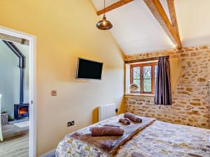 a bedroom with a bed and a tv on the wall at 1 bed in Beaminster 75193 in Mosterton