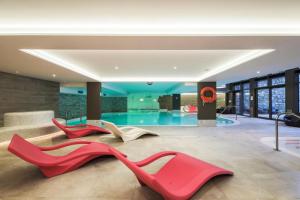 a lobby with three red shoes and a swimming pool at Résidence Premium L'Hévana - maeva Home - Appartement 3 pièces 6 personne 674 in Les Allues