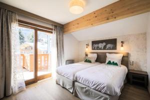 a bedroom with a large bed and a large window at Résidence Premium L'Hévana - maeva Home - Appartement 3 pièces 6 personnes Prestige MAE-3674 in Les Allues +29 photos