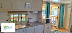 una cucina con lavandino e piano di lavoro di Mobile home Viareggio - Camping Paradiso- Including airco -Zona Gialla 016 a Viareggio