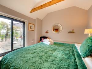 a bedroom with a large green bed with a window at 1 Bed in Gillamoor G0029 in Gillamoor
