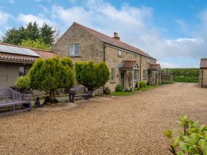 a large stone house with a gravel driveway at 1 Bed in Gillamoor G0029 in Gillamoor