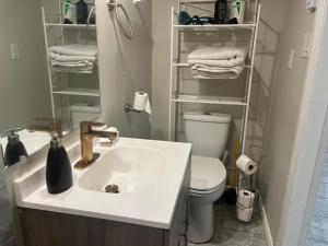 uma casa de banho com lavatório, WC e toalhas em beautiful two bedroom water front em Victoria