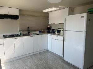 uma cozinha com armários brancos e um frigorífico branco em beautiful two bedroom water front em Victoria