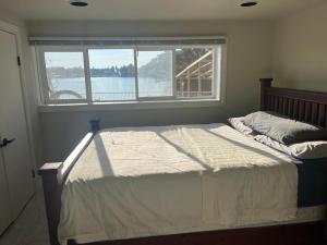 uma cama num quarto com uma grande janela em beautiful two bedroom water front em Victoria