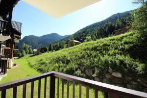 a balcony with a view of a green hill at Chalets Du Thabor - 2 Pièces pour 4 Personnes 82 in Modane