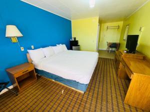 a bedroom with a large bed and a television at Crown Inn in Raton