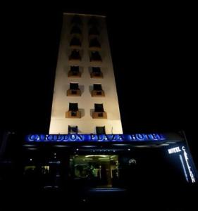 um edifício alto com uma torre de relógio à noite em Carillon Plaza Hotel em São Paulo