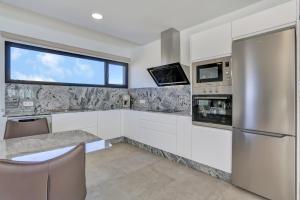 a kitchen with white cabinets and a window at Mariposas Lajares 5 in Lajares