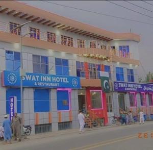 un edificio con gente parada frente a él en Swat Inn Hotel en Mingora