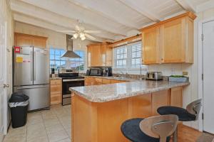 a kitchen with wooden cabinets and stainless steel appliances at Smart Pelican by Oak Island Accommodations in Oak Island