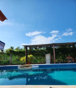 een zwembad met een tafel en een pergola bij Villa del Sol in Barra de Potosi