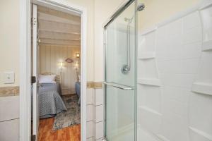 a glass door to a bathroom with a bedroom at Smart Pelican by Oak Island Accommodations in Oak Island +109 photos