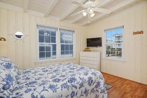 a bedroom with a bed and a ceiling fan at Smart Pelican by Oak Island Accommodations in Oak Island