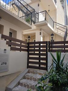 a house with a fence and stairs in front of it at LB Luxury Apartments in Volos