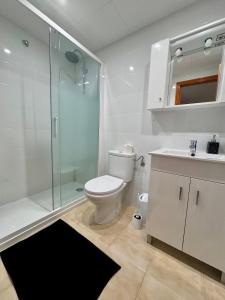 uma casa de banho com um WC, um chuveiro e um lavatório. em Apartamento Agua Rosa em Torrevieja