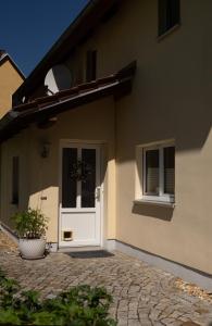 une maison avec une porte blanche et une fenêtre dans l'établissement Haus am Berzdorfer See, à Görlitz