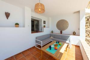 ein Wohnzimmer mit einem Sofa und einem Tisch in der Unterkunft Villa Franmarco by Villa Plus in Nerja