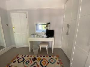 Zimmer mit einem weißen Schreibtisch mit einem Computer. in der Unterkunft Rooms in Hadleigh,Essex in Hadleigh
