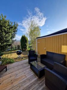 a patio with a couch and chairs on a wooden deck at Radhus nära sjö, Arlanda och Stockholm in Upplands-Väsby