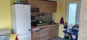 a kitchen with a white refrigerator and wooden cabinets at Działka u Zbycha - na wyłączność - duży teren 