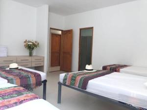 a bedroom with two beds and a wooden cabinet at Espectacular Cabaña W - vista al mar y piscina privada in Santa Veronica