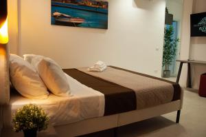 a bedroom with a bed with a painting on the wall at Sicily Luxury Rooms in Palermo