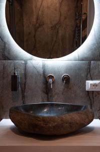 a bathroom with a stone sink in front of a mirror at Sicily Luxury Rooms in Palermo