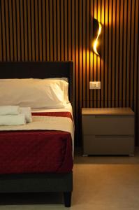 een slaapkamer met een bed en een lampje aan de muur bij Sicily Luxury Rooms in Palermo