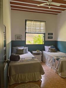 1 dormitorio con 2 camas y ventana en Hospedaria Nova Era, en Rio Novo